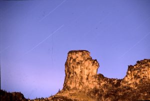 a rock formation with a purple night sky as the backdrop