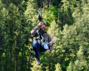 man flies through the air on a zipline