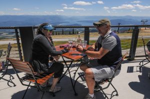 a man and a woman enjoy glasses of wine on a patio