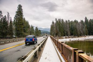 cars drive over a snowy river