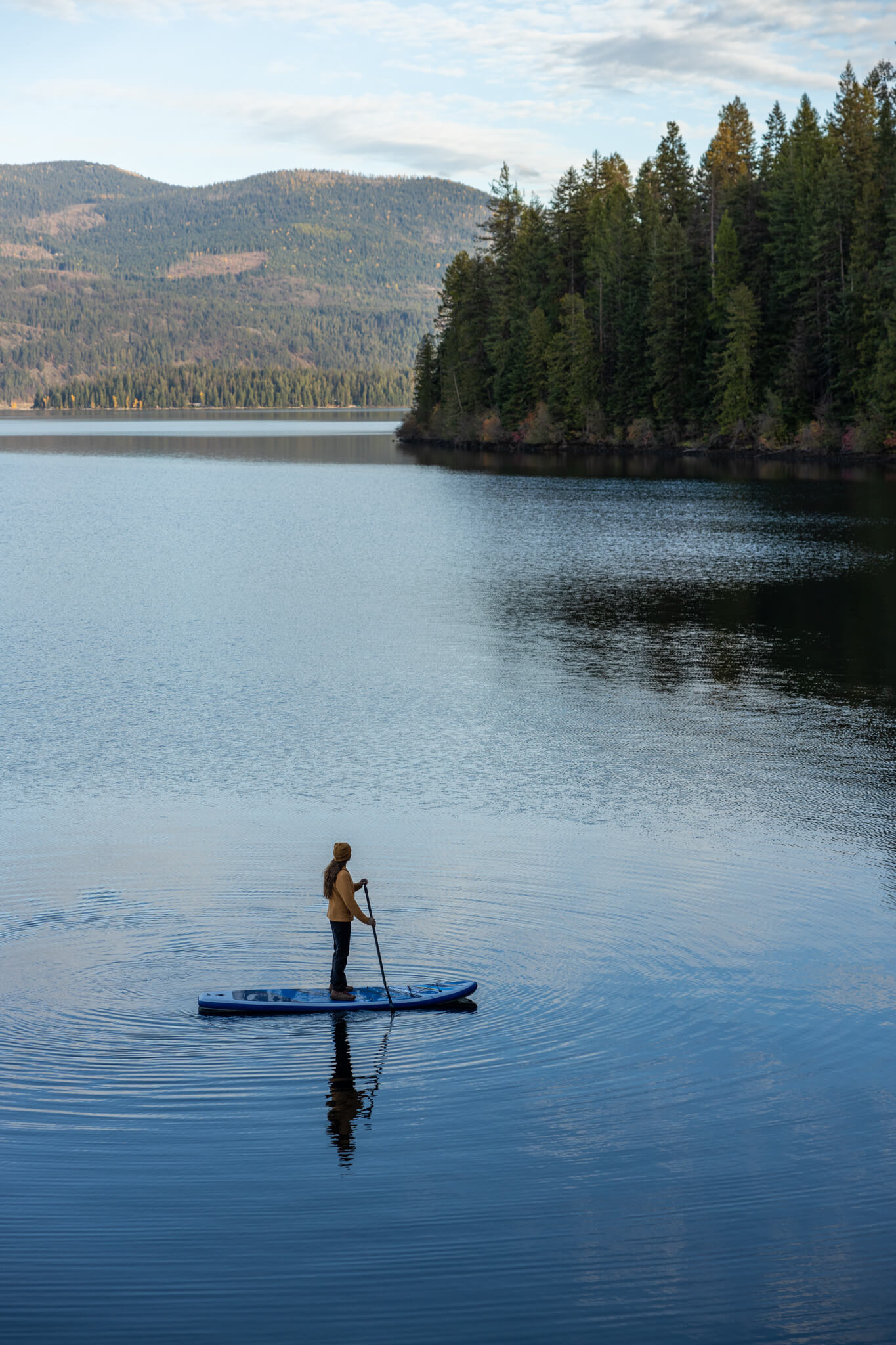 Priest Lake with calm blue waters, surrounded by dense forest and mountain scenery in North Idaho.