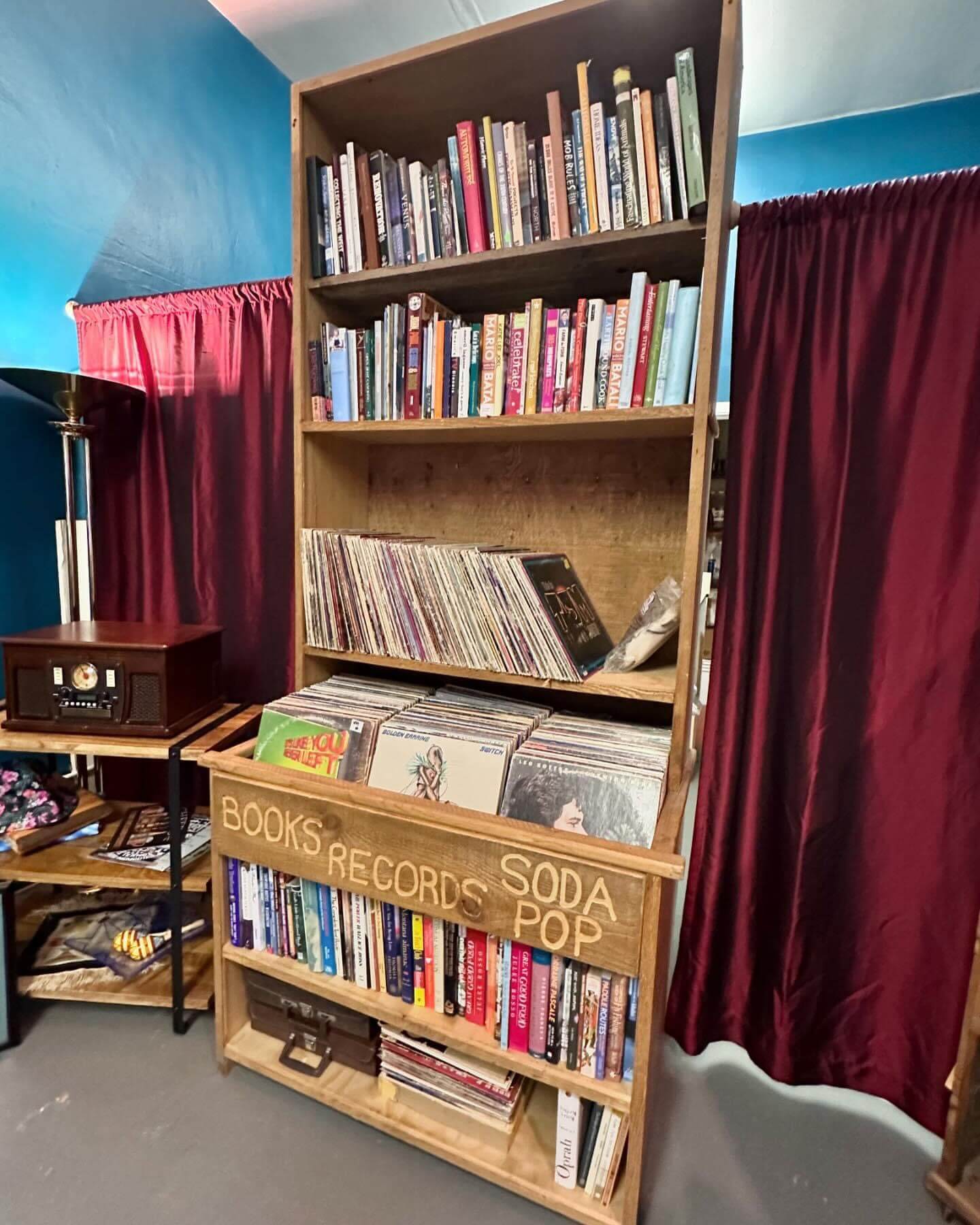 A tall bookshelf filled with several books and records inside Hidden Gems Shoppe.