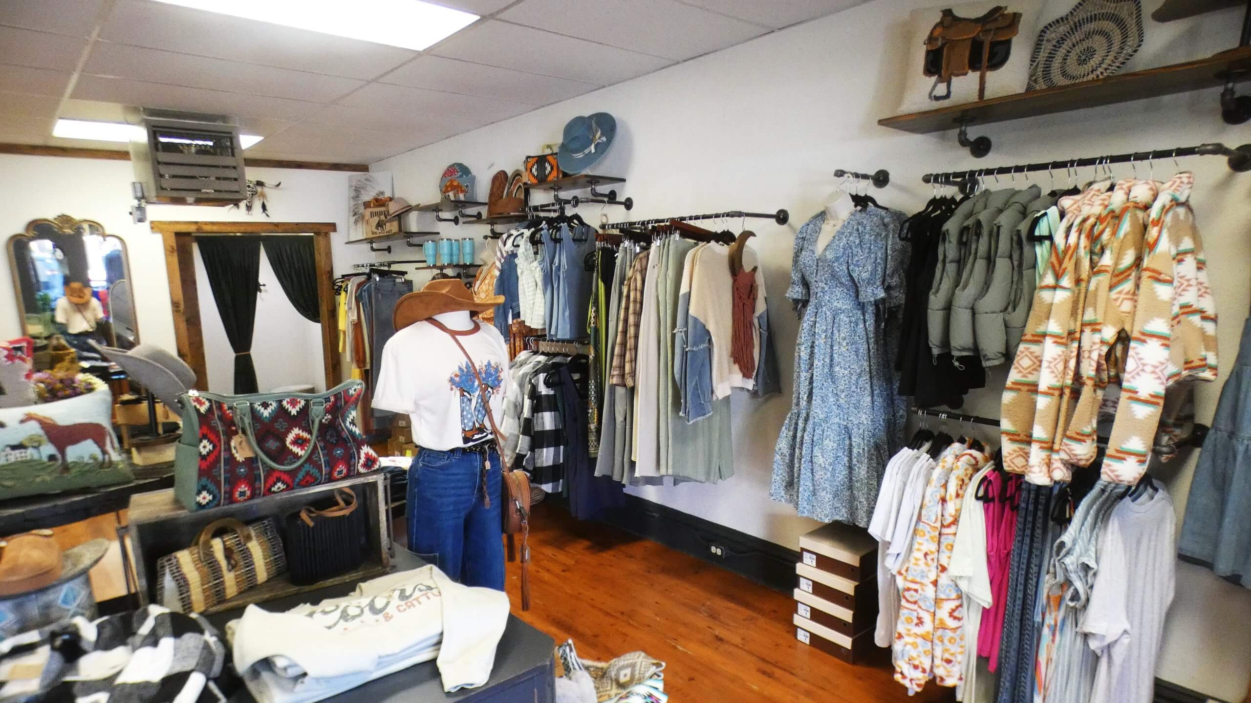 Several items of clothing hanging on racks and displayed on shelves inside the Tesemini & Company shop.